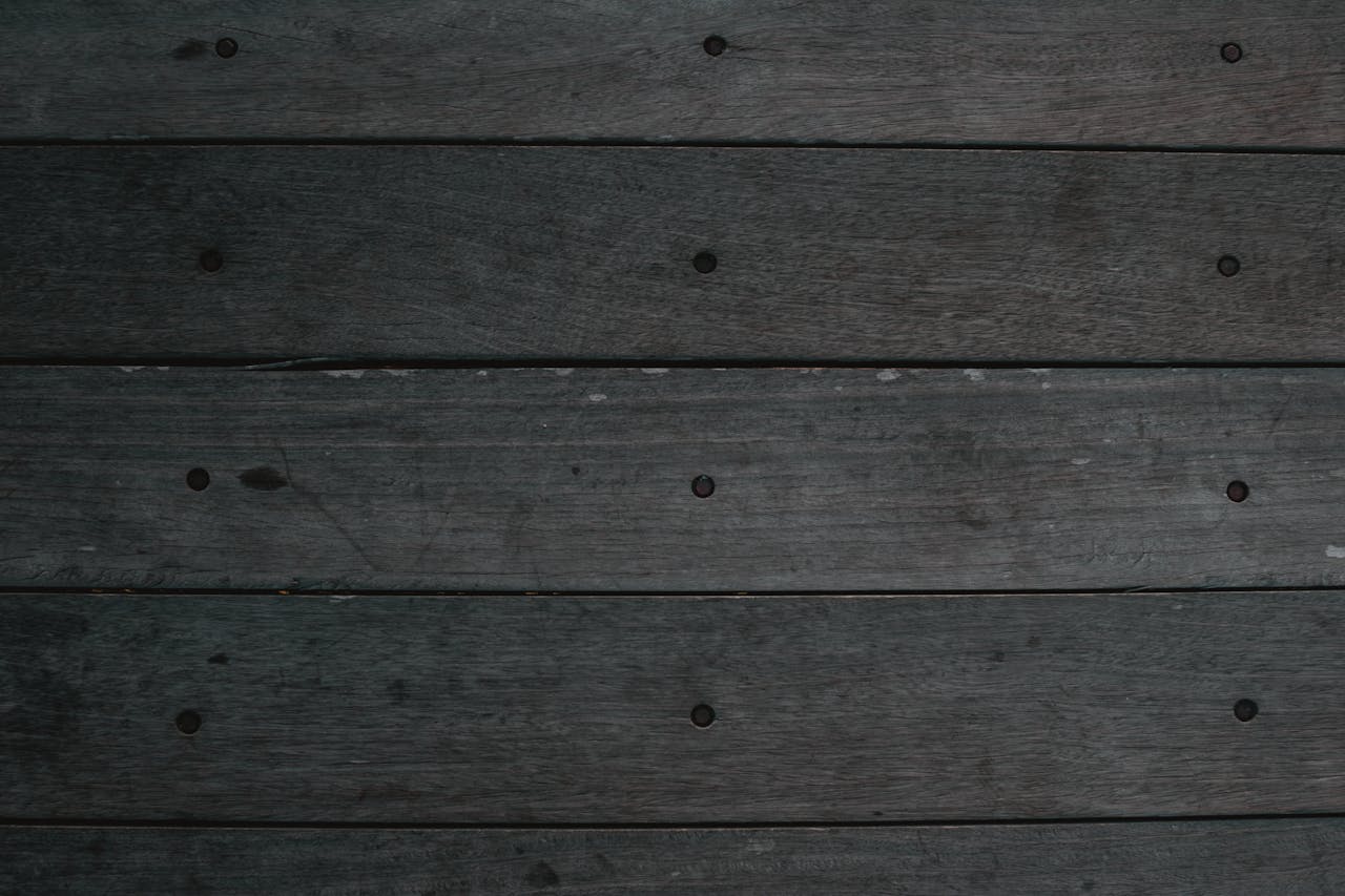 Close-up of dark wooden planks with natural grain texture, ideal for backgrounds and design work.